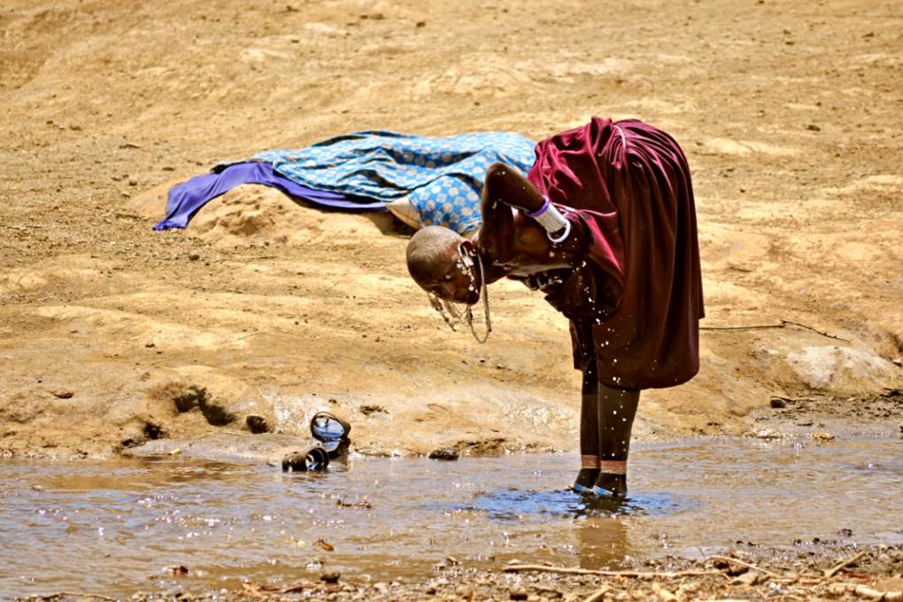 Chica Masai lavándose en el río